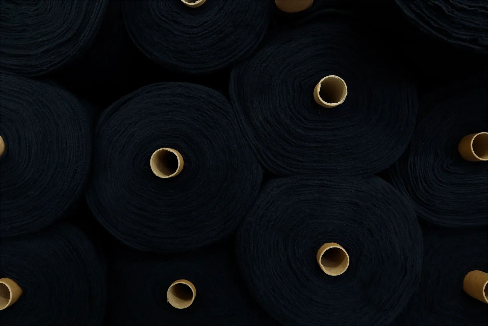 Circular black fabric rolls in a textile setting
